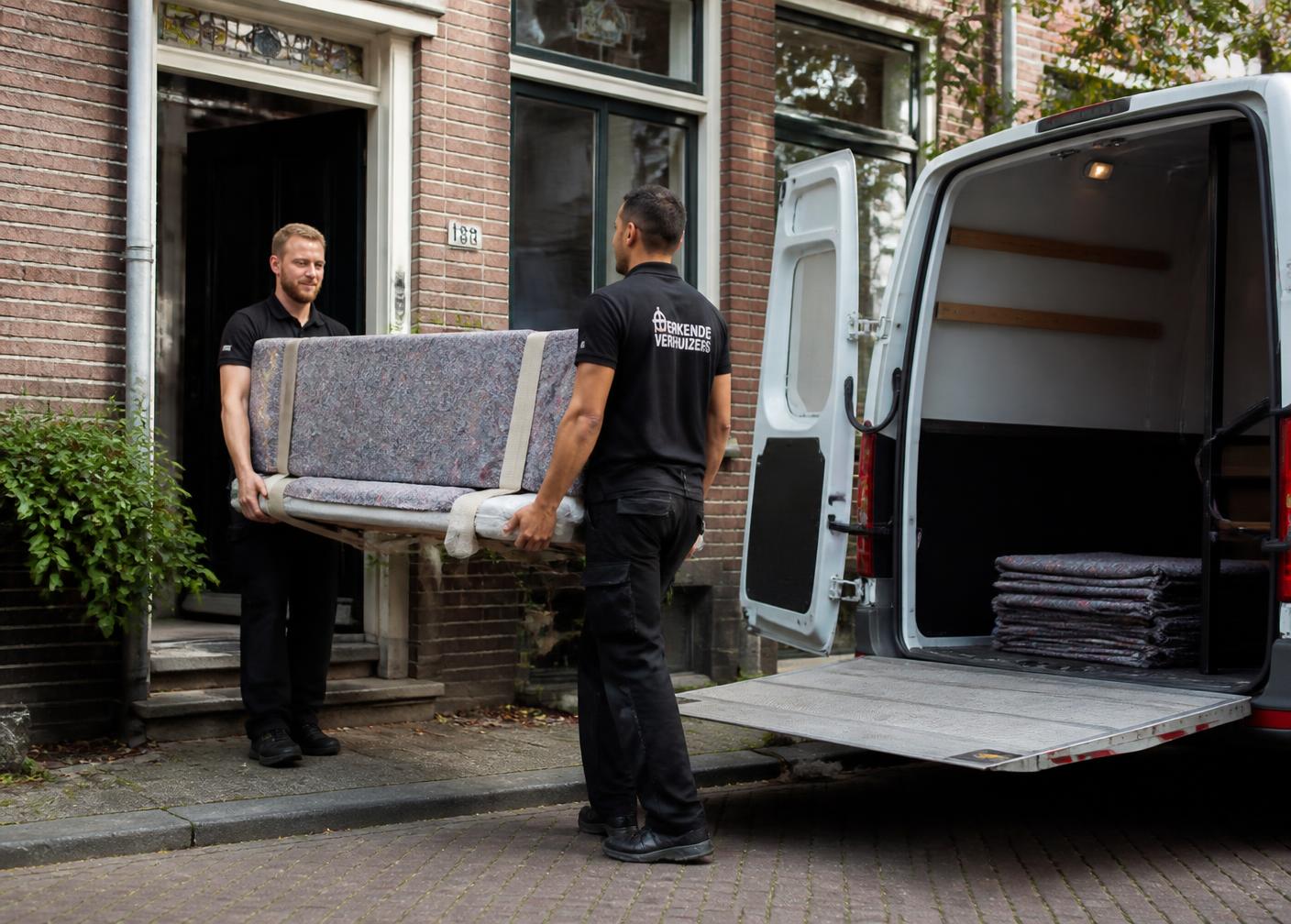 Verhuizers dragen zorgvuldig ingepakte meubels naar een verhuiswagen